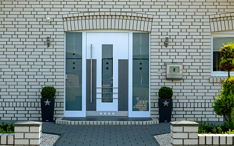 weiße Haustüre von Busmann eingebaut in Haus mit weißem Klinker