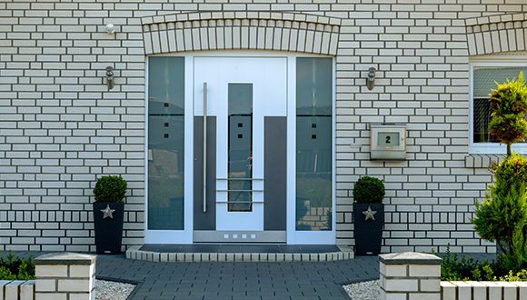 weiße Haustüre von Busmann eingebaut in Haus mit weißem Klinker