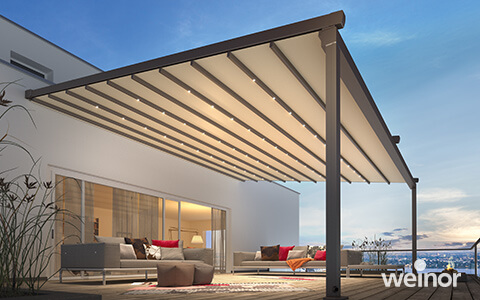 Pergola Markise PergoTex II auf einer Dachterrasse mit beigem Tuch und LED-Lichtleisten.