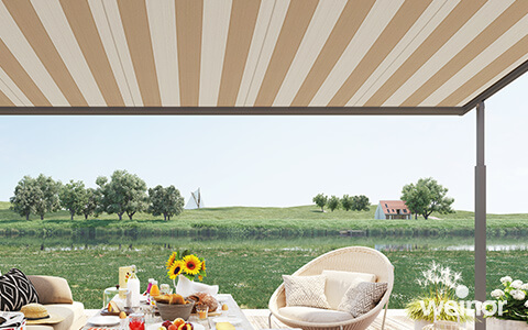 Pergola Markise Plaza Viva von weinor mit gestreiftem Tuch in Beige Tönen. Darunter ein gedeckter Frühstückstisch.